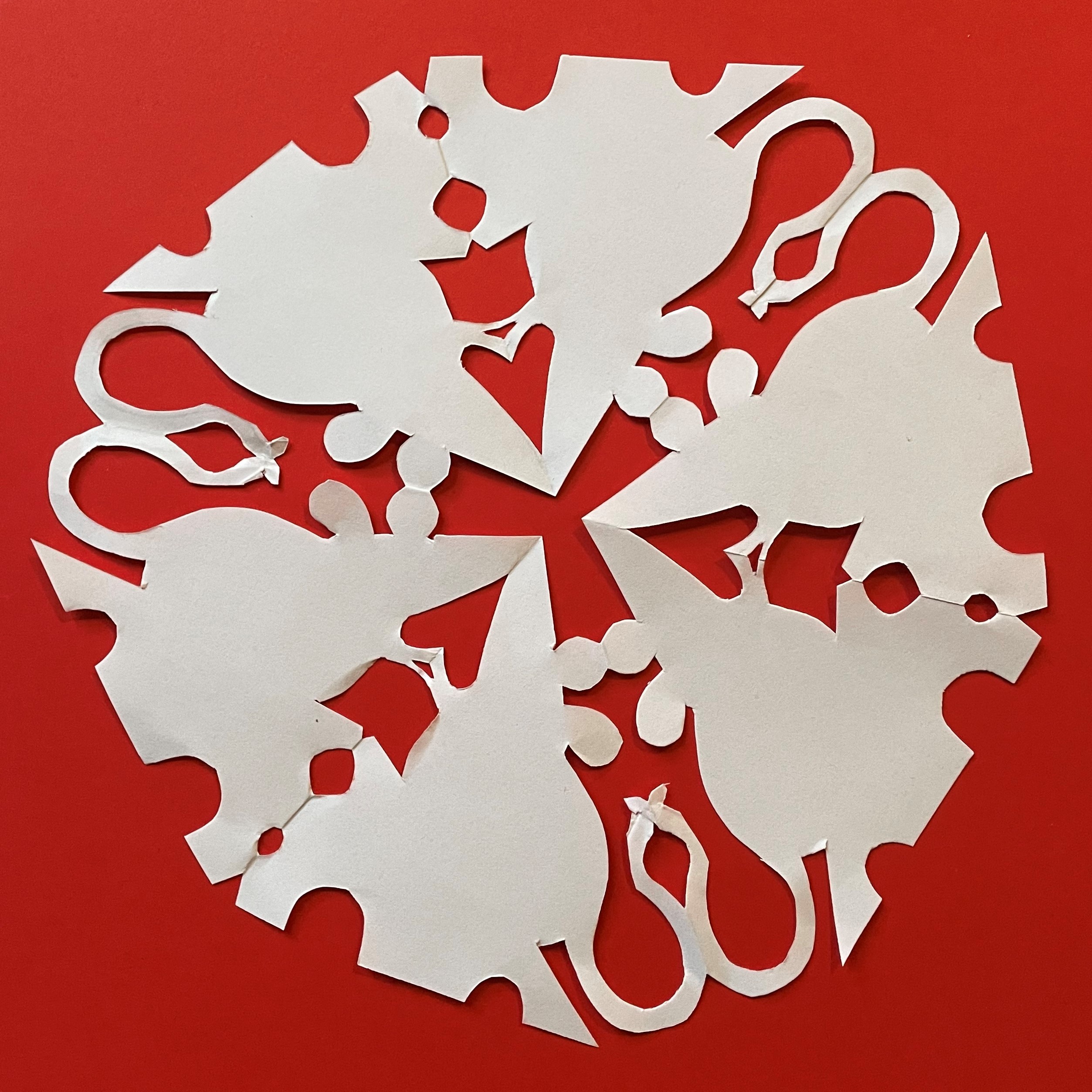 Photo of a papercut snowflake in the shape of mice on cheese